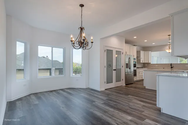 a view of a kitchen with a refrigerator wooden floor and a kitchen