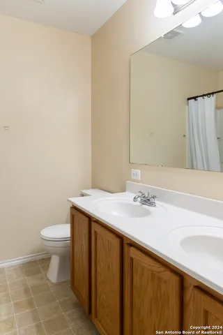 a bathroom with a granite countertop sink a toilet and a mirror
