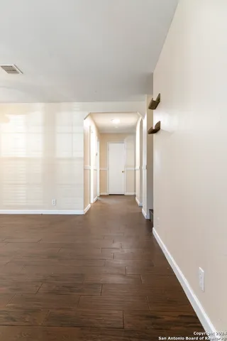 a view of a hallway with wooden floor