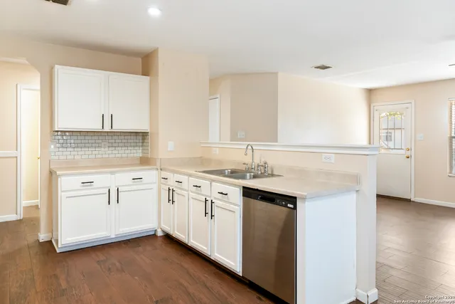 a kitchen with granite countertop white cabinets and white appliances