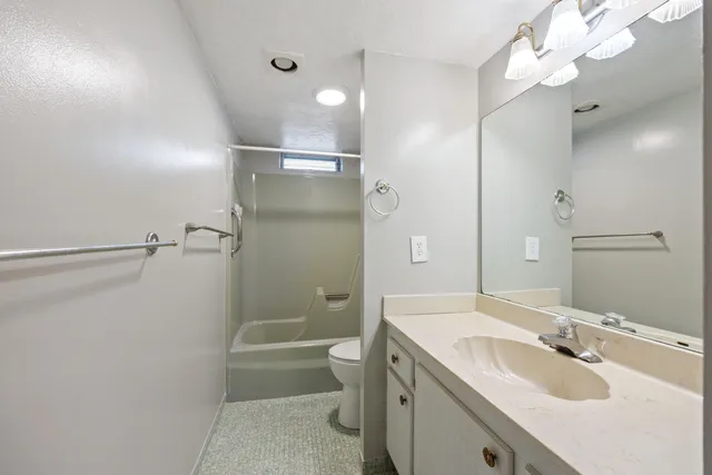a bathroom with a sink a toilet a tub and mirror