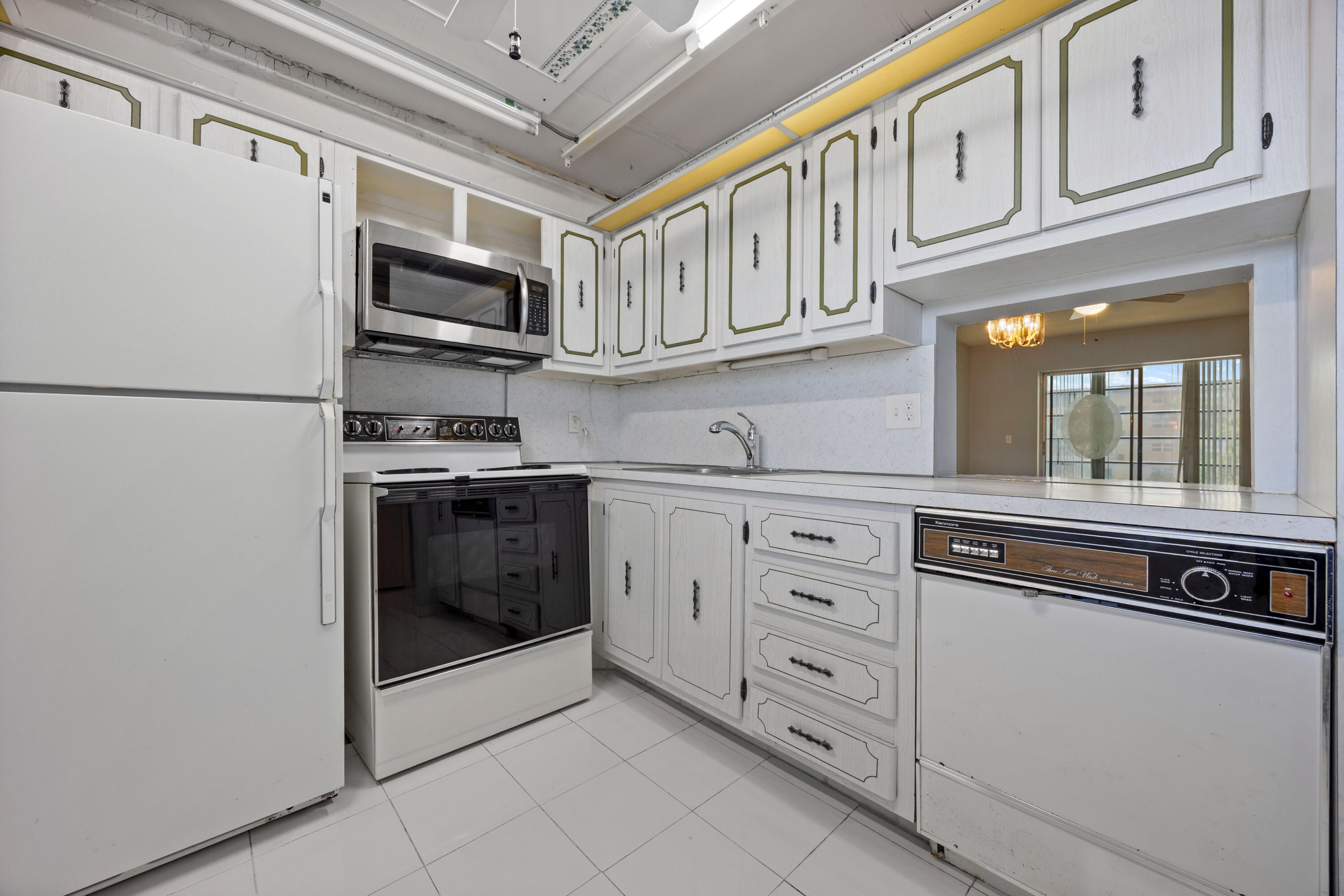 230 Northeast 26th Avenue, Unit 206 Boynton Beach, FL 33435 - Photo 4 of 25 a kitchen with stainless steel appliances granite countertop a refrigerator and a stove top oven