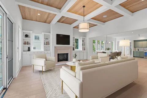 a living room with furniture a flat screen tv and kitchen view