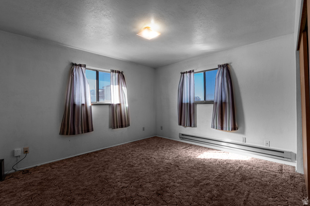 1208 East Tidwell Road Loa, UT 84747 - Photo 21 of 40 Carpeted spare room featuring a baseboard radiator and a textured ceiling