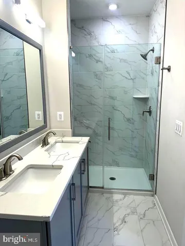 a bathroom with a sink a shower and a mirror