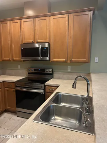 a kitchen with a sink a microwave and cabinets
