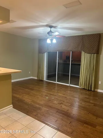 a view of an empty room with wooden floor and cabinet