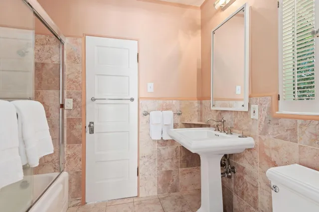 a bathroom with a sink a toilet and shower