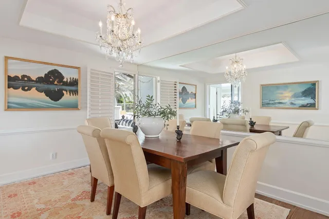 a view of a dining room with furniture a chandelier and wooden floor