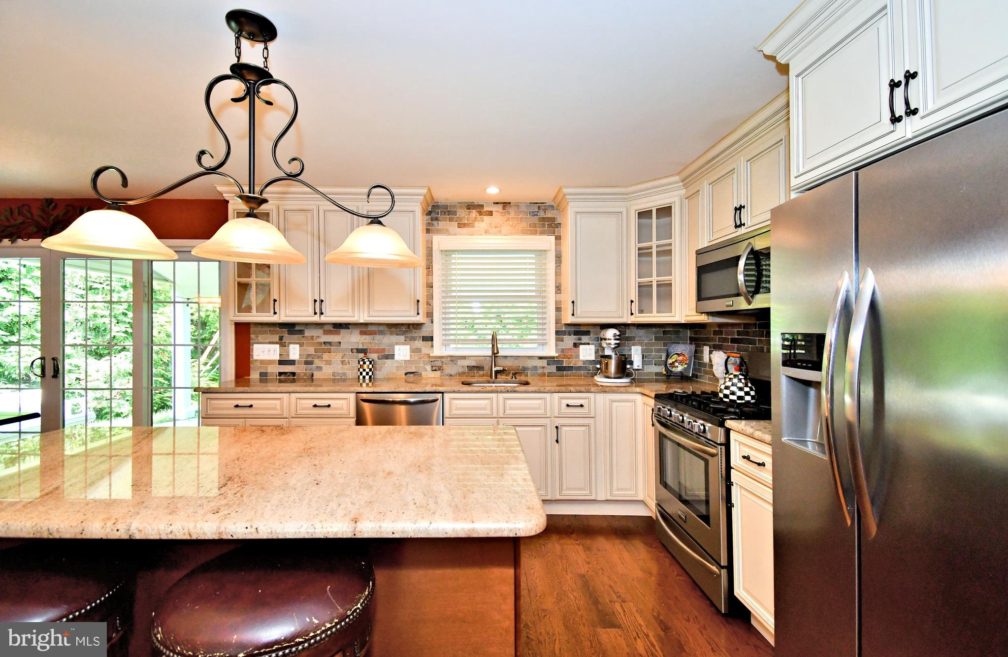 1014 Anna Road Huntingdon Valley, PA 19006 - Photo 11 of 54 a kitchen with stainless steel appliances granite countertop a stove top oven a sink dishwasher and white cabinets with wooden floor