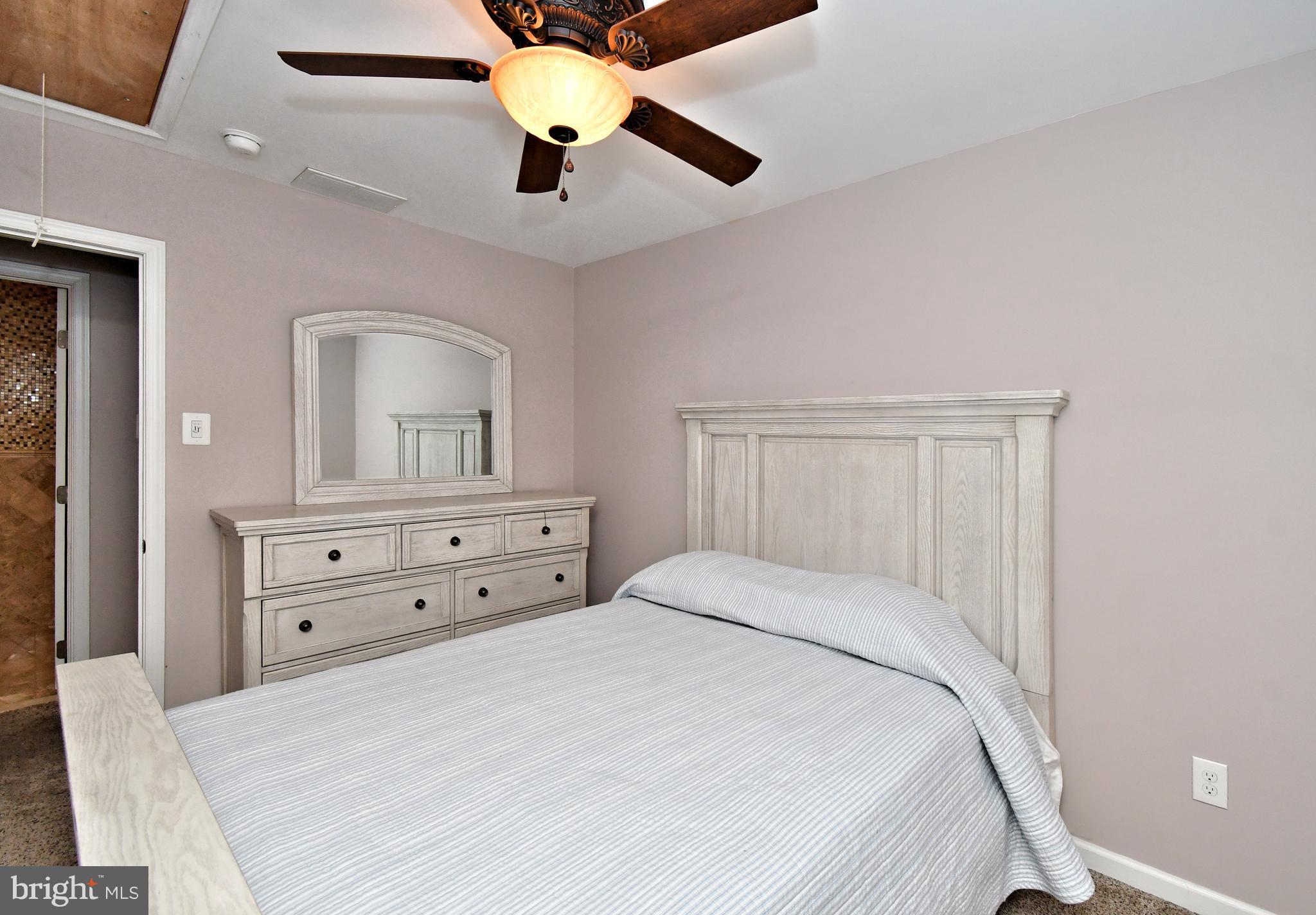 1014 Anna Road Huntingdon Valley, PA 19006 - Photo 37 of 54 a bedroom with a bed a chandelier and a dresser