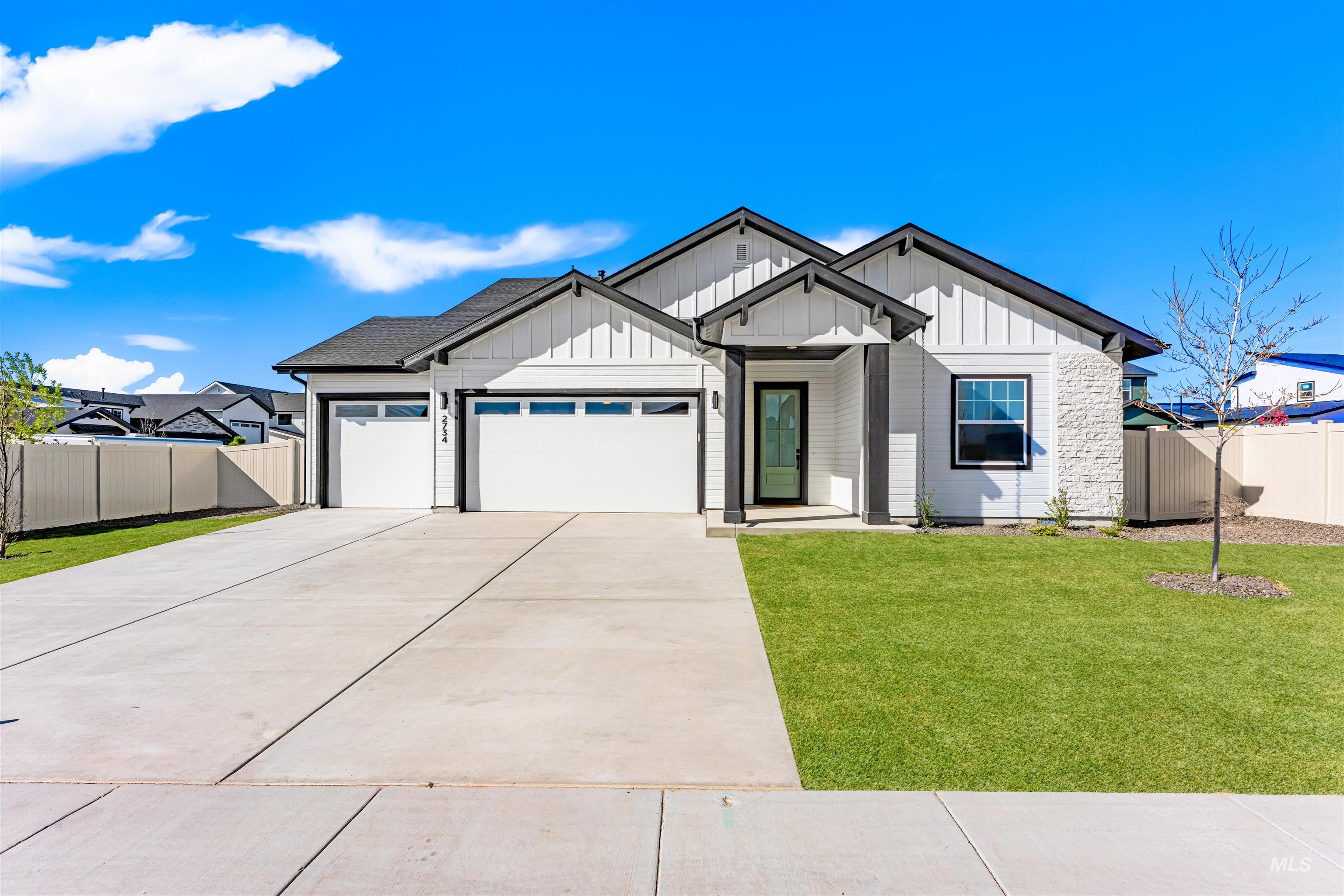 Modern farmhouse with a garage, board and batten siding, and concrete driveway