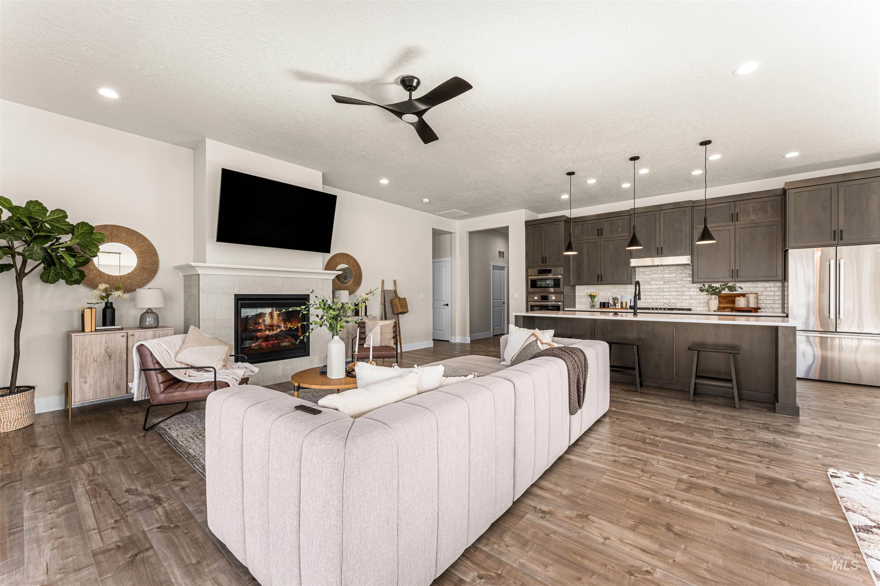 2787 West Warlander Street Meridian, ID 83642 - Photo 3 of 34 Living room with a ceiling fan, light wood-style floors, a fireplace, and recessed lighting
