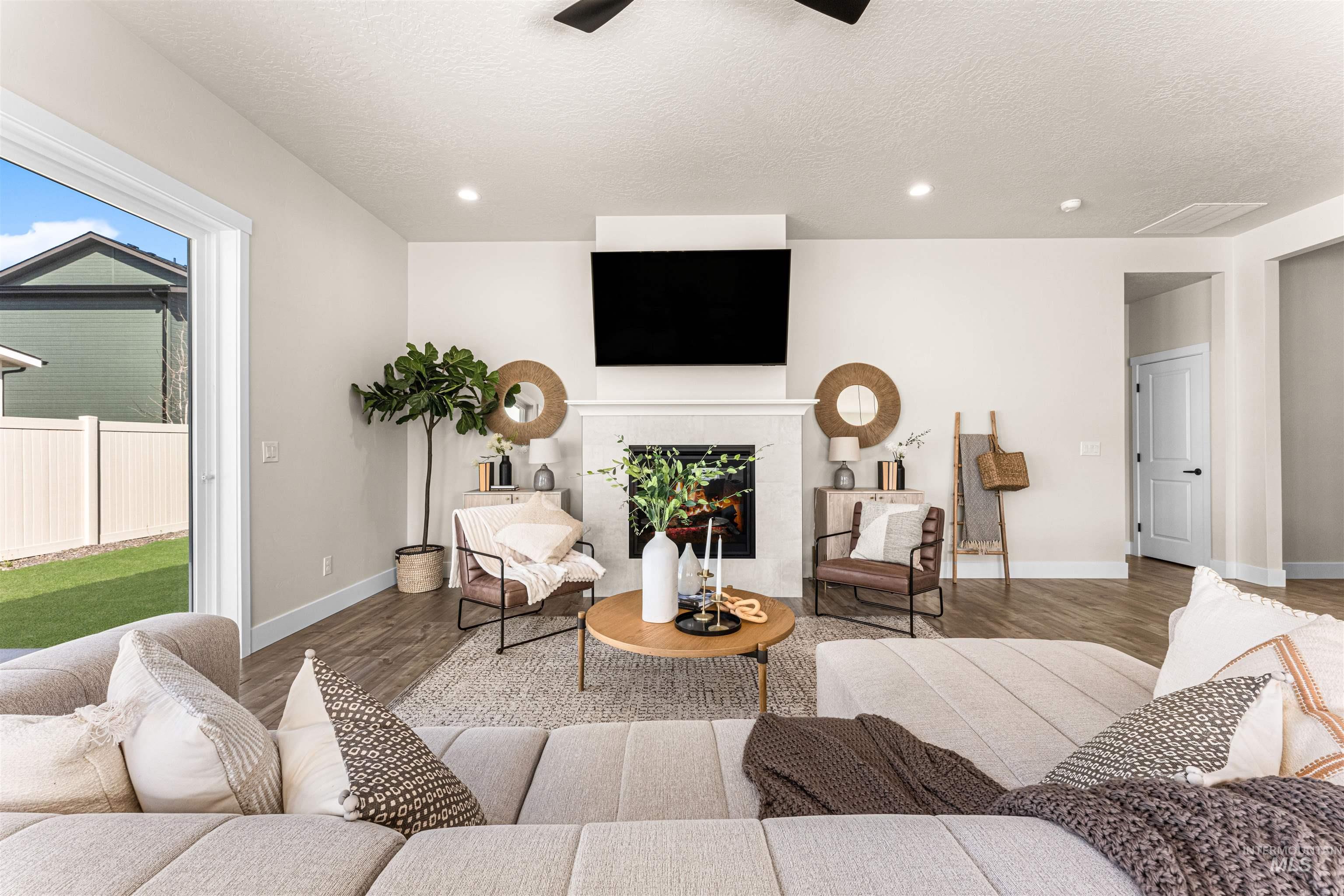 2787 West Warlander Street Meridian, ID 83642 - Photo 4 of 34 Living area with wood finished floors, ceiling fan, a tiled fireplace, recessed lighting, and a textured ceiling