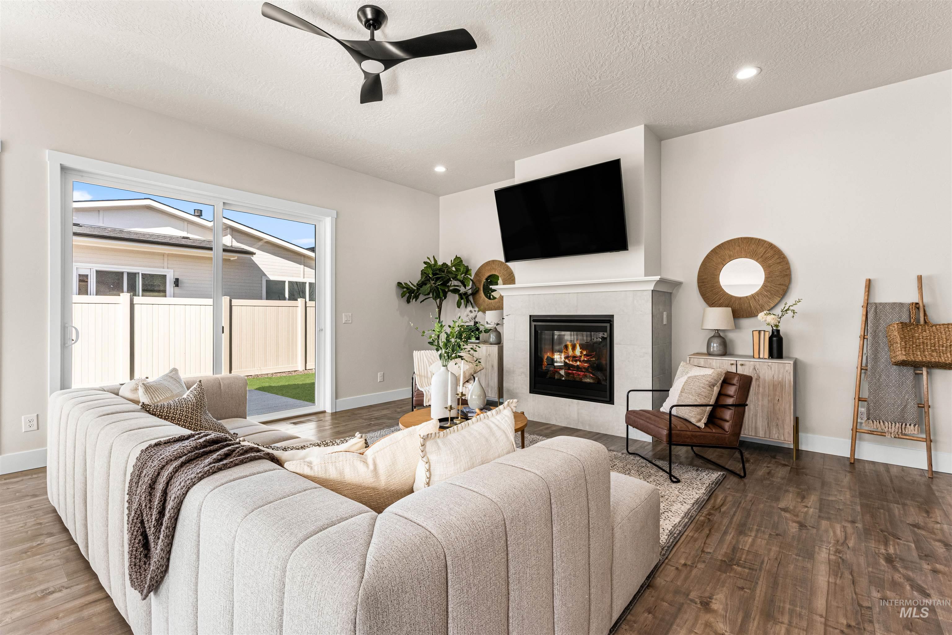 2787 West Warlander Street Meridian, ID 83642 - Photo 5 of 34 Living room featuring a ceiling fan, wood finished floors, a fireplace, recessed lighting, and a textured ceiling