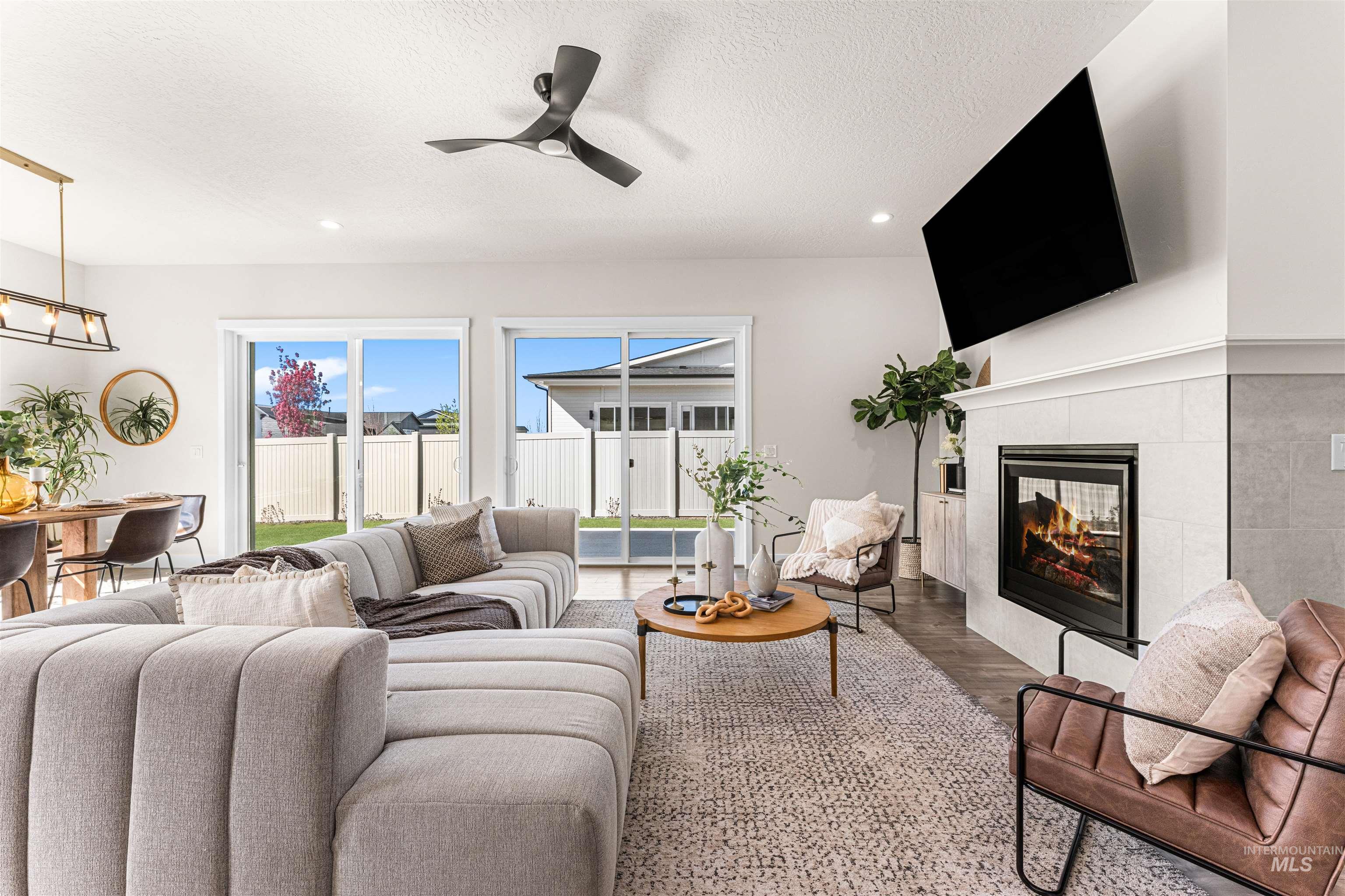 2787 West Warlander Street Meridian, ID 83642 - Photo 6 of 34 Living room with wood finished floors, a ceiling fan, a fireplace, a textured ceiling, and recessed lighting