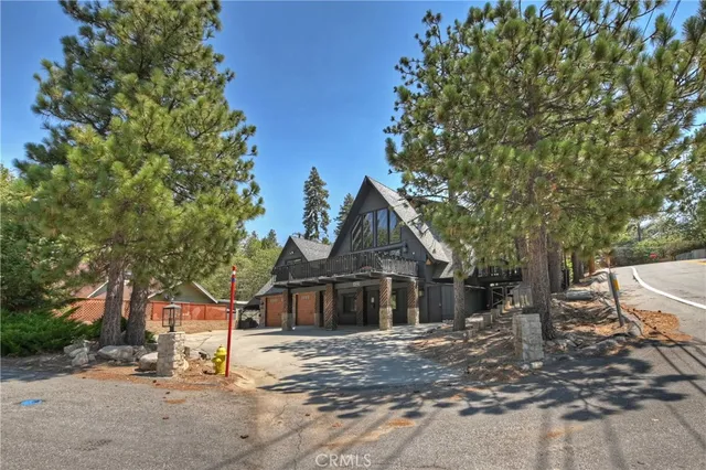 a front view of a house with a tree