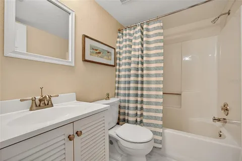 a bathroom with a sink a toilet and shower curtain