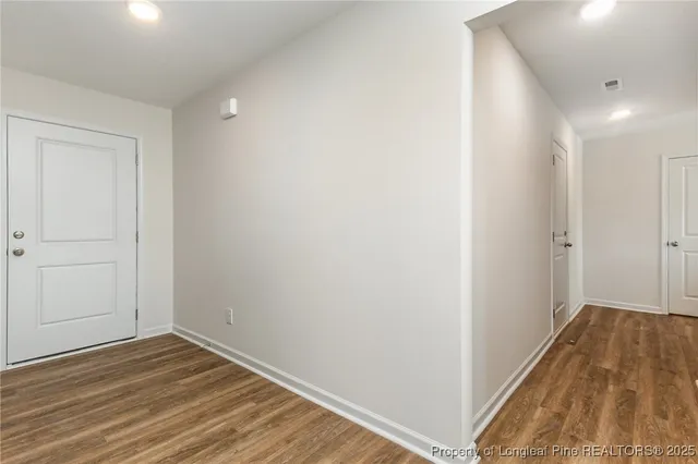 a view of a hallway with wooden floor