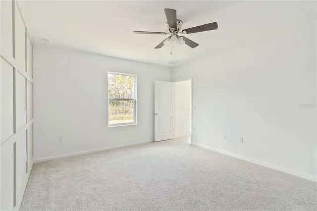 an empty room with a window and a fan