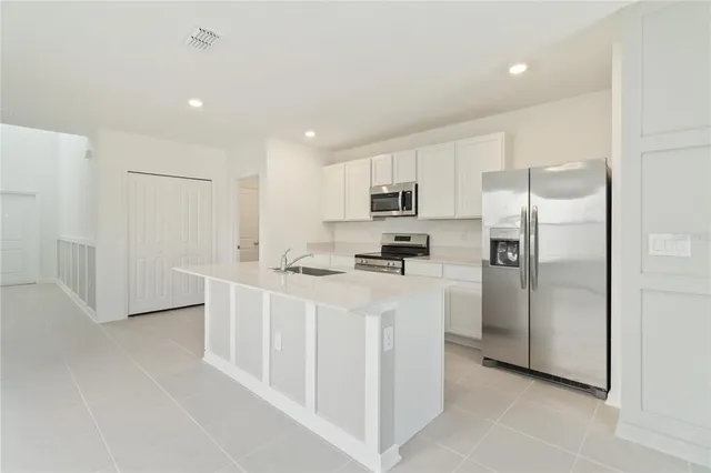 a kitchen with white cabinets and stainless steel appliances