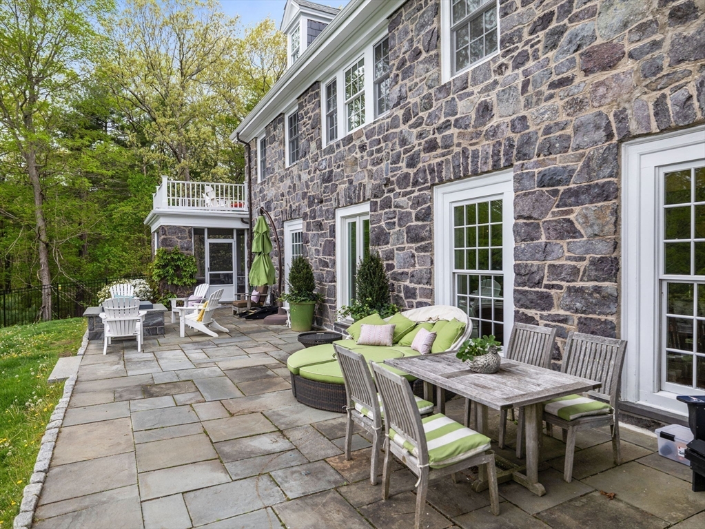 90 Burr Drive Needham, MA 02492 - Photo 38 of 41 a view of a patio with table and chairs and floor to ceiling window