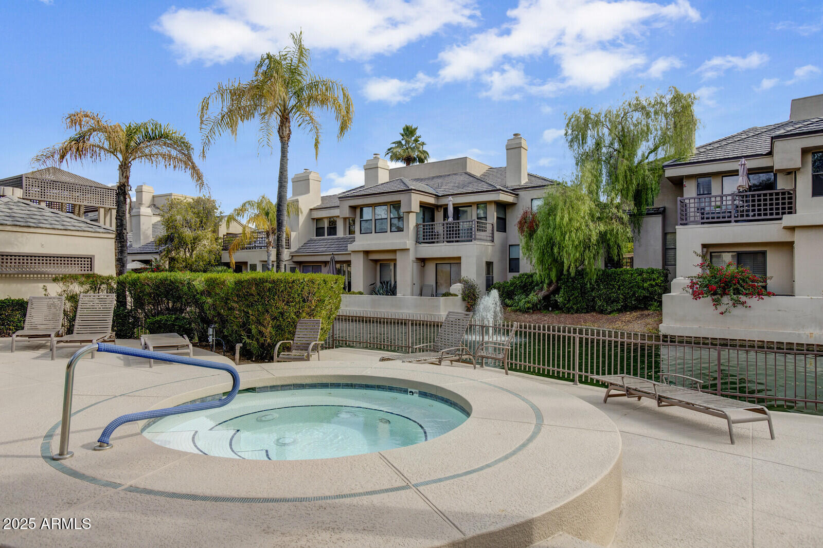 7272 East Gainey Ranch Road, Unit 120 Scottsdale, AZ 85258 - Photo 23 of 26 a view of a house with a swimming pool and a yard