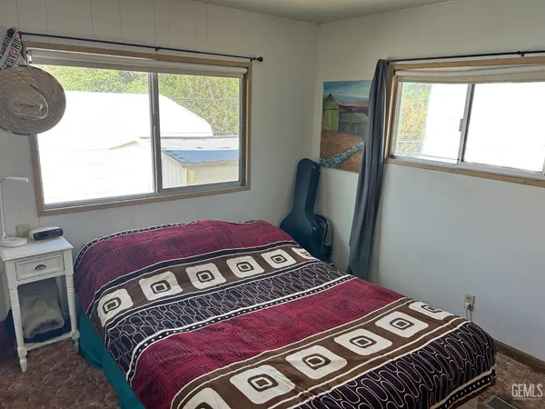 a bedroom with a bed next to a window