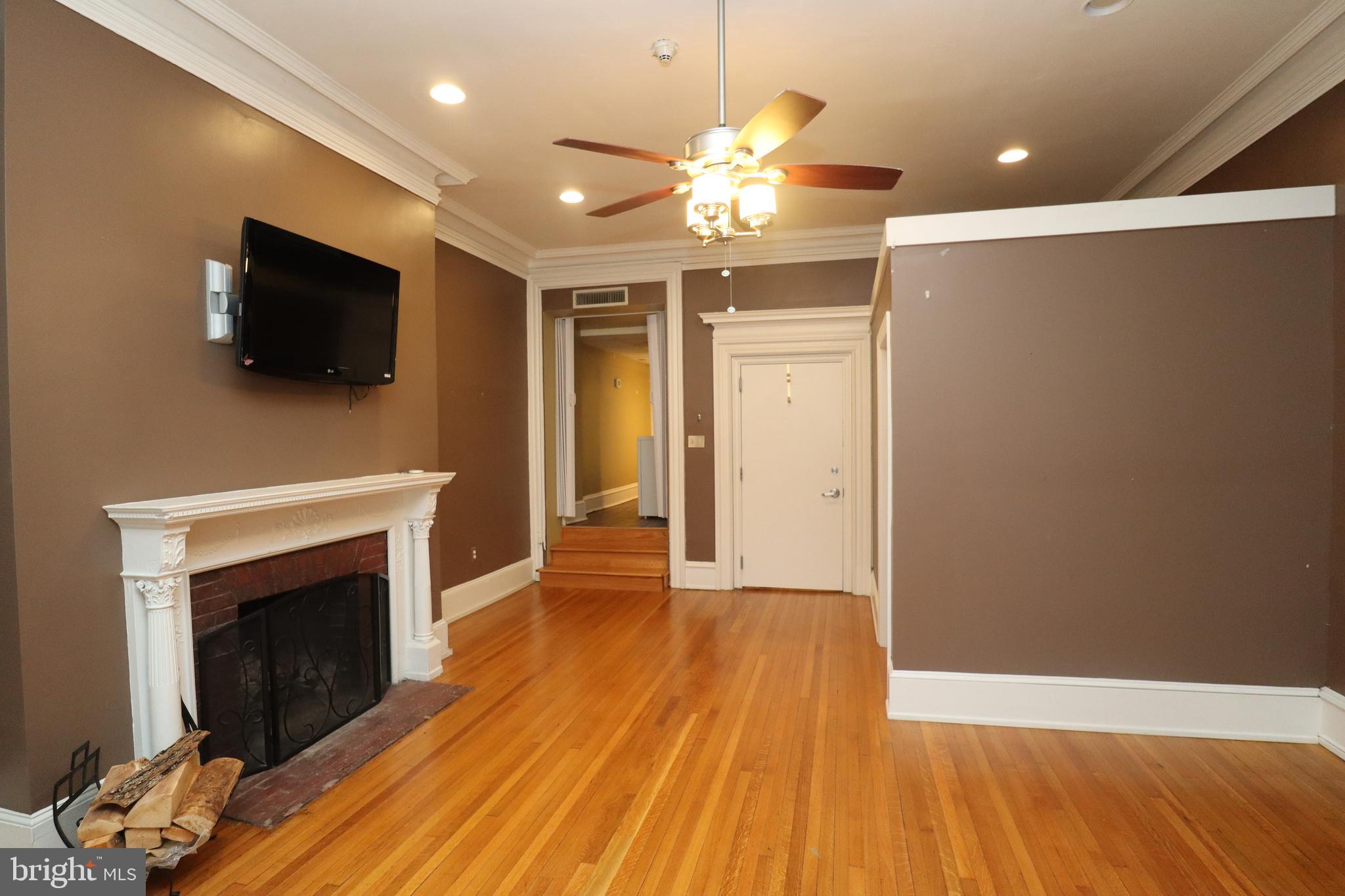 1608 Spruce Street, Unit 2 Philadelphia, PA 19103 - Photo 1 of 19 a view of a livingroom with a fireplace wooden floor and chandelier