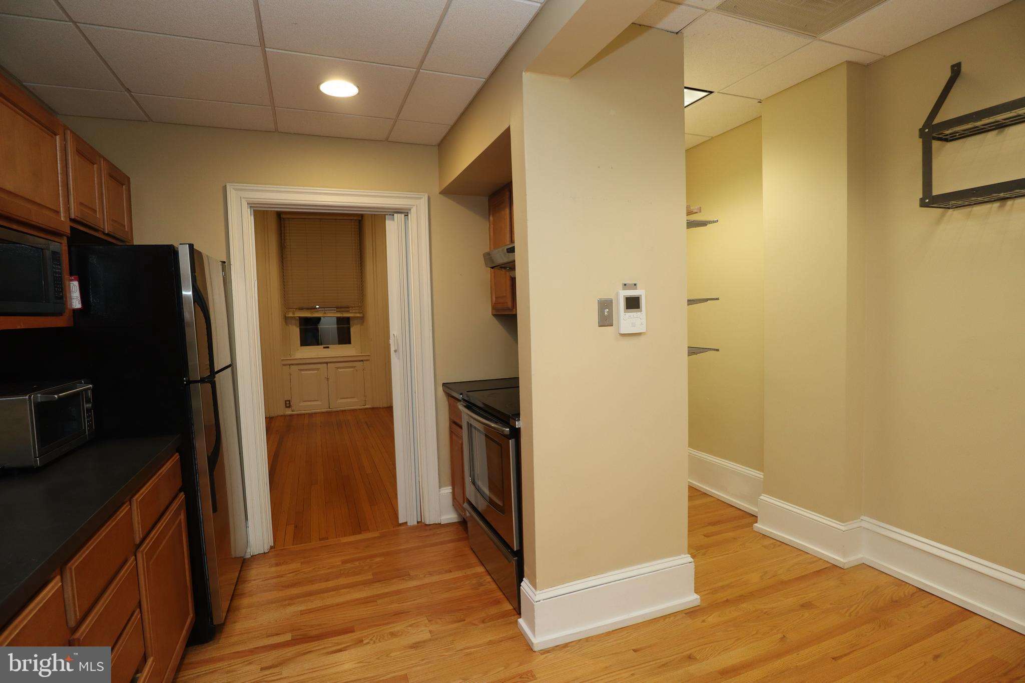 1608 Spruce Street, Unit 2 Philadelphia, PA 19103 - Photo 11 of 19 a view of a refrigerator in kitchen and wooden floor