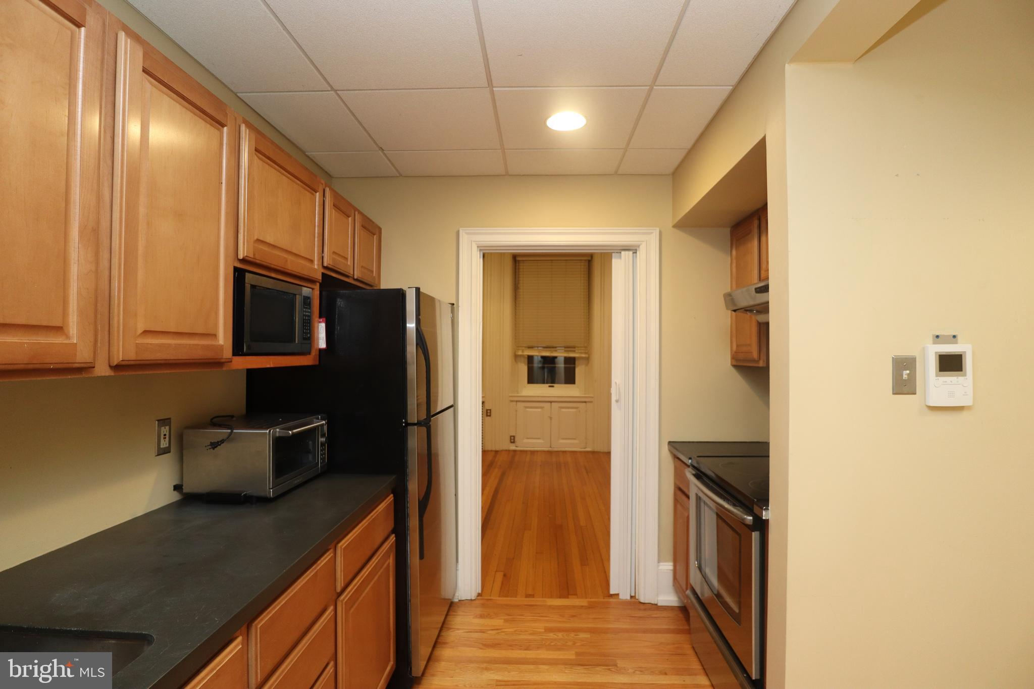 1608 Spruce Street, Unit 2 Philadelphia, PA 19103 - Photo 15 of 19 a kitchen with stainless steel appliances granite countertop a refrigerator and a sink