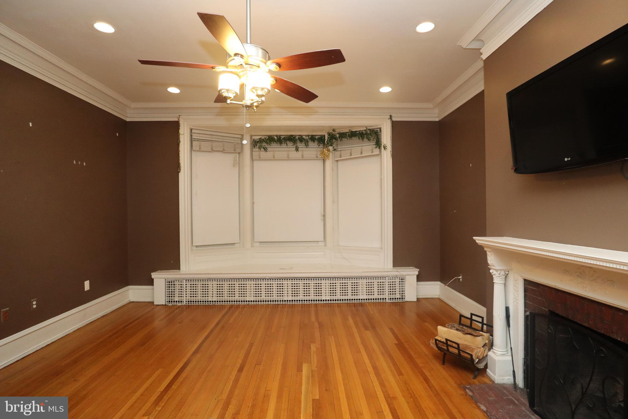 1608 Spruce Street, Unit 2 Philadelphia, PA 19103 - Photo 2 of 19 a view of an empty room with wooden floor and a fireplace