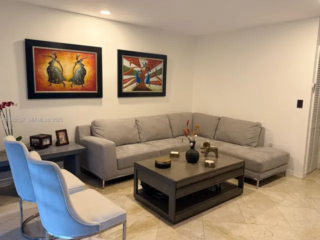 a living room with furniture a couch and paintings on wall