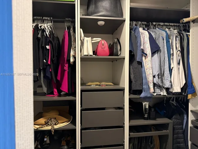 a view of walk in closet with clothes and shoes