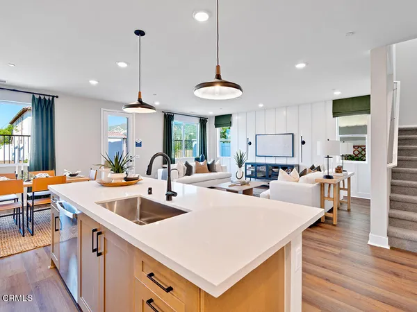 a large kitchen with sink a counter space appliances and wooden floor