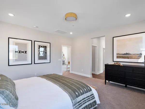 a bedroom with a bed and a painting on the wall