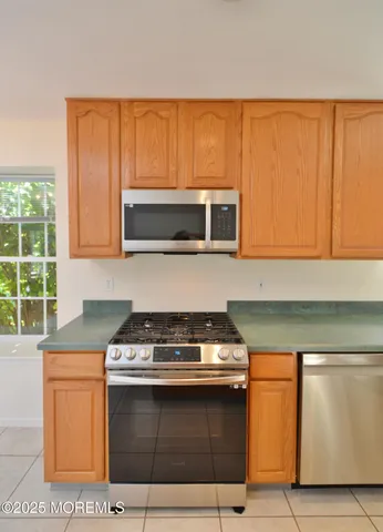 a kitchen with stainless steel appliances a stove a microwave and white cabinets