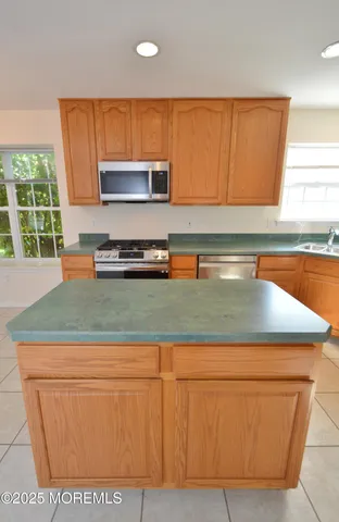 a large kitchen with granite countertop a sink a stove a washer and dryer