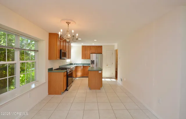 a large kitchen with stainless steel appliances a large counter top a stove a chimney a sink and dishwasher