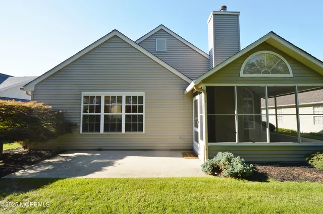 a front view of a house with a yard and potted plants