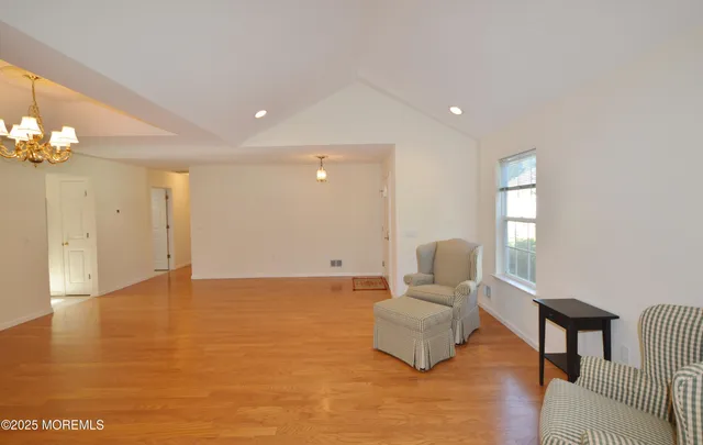 a view of a livingroom with a fireplace a chandelier and wooden floor