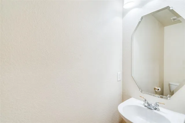 an empty room with chandelier fan and windows