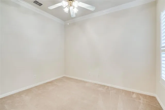 an empty room with a chandelier fan