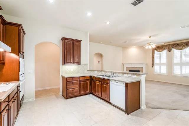 a view of a kitchen with stainless steel appliances granite countertop a stove and a sink