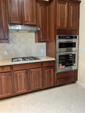 a kitchen with granite countertop cabinets and steel appliances