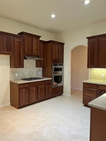 a kitchen with granite countertop wooden cabinets and stainless steel appliances