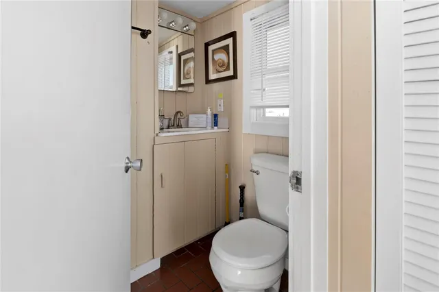 a bathroom with a granite countertop toilet and a sink
