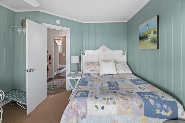 a view of a bedroom with a bed and wooden floor