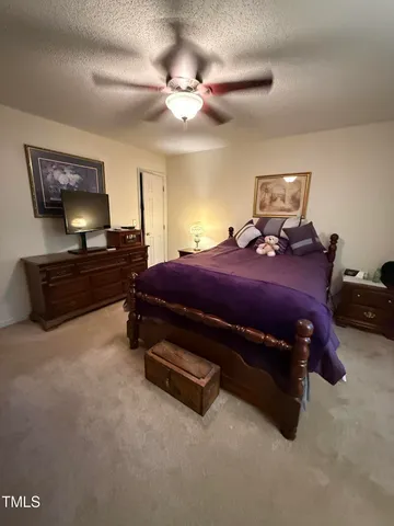 a bed room with a bed and a ceiling fan