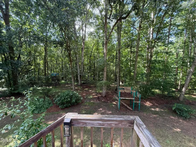 a roof deck with chairs and wooden floor